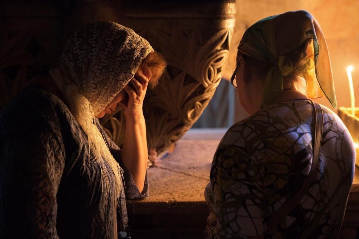 Две женщины читают молитву в Храме Гроба Господня.