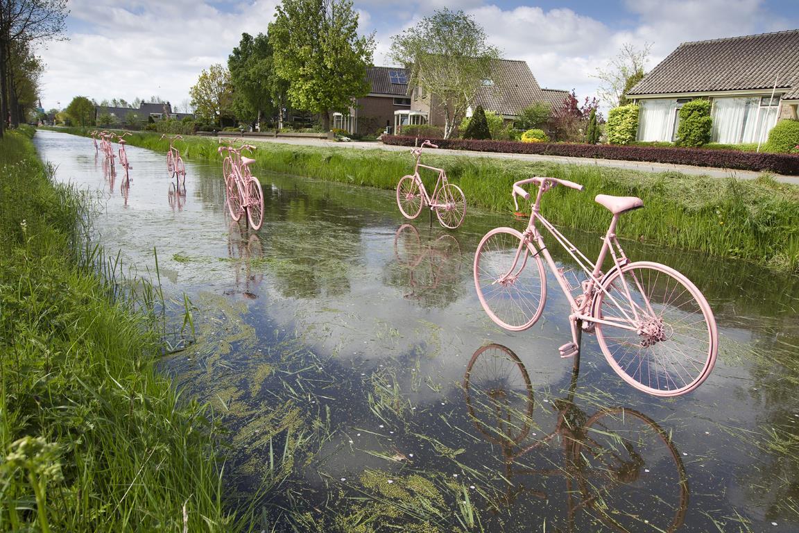 Розовые велосипеды над водой празднуют прибытие велогонки "Giro d'Italia" в Schalkwijk, небольшой городк за пределами Утрехт, Нидерланды.