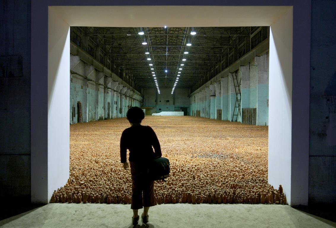 Посетитель просматривает массивную скульптурную инсталляцию, заполняющую заводской склад на выставке британского художника Энтони Гормли (Antony Gormley) под названием "Азиатское поле" (Asian Field) в Шанхае. 