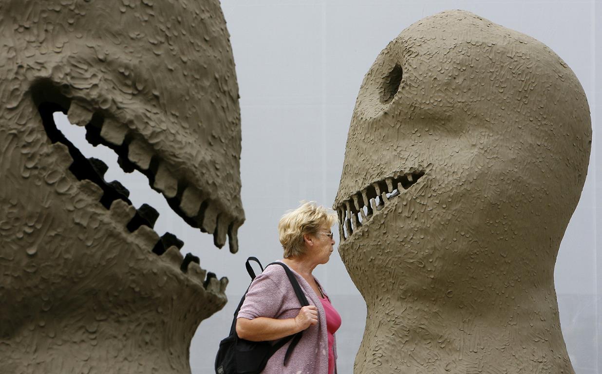 Женщина проходит мимо скульптуры перед главным входом в "Art 39" в Базеле.