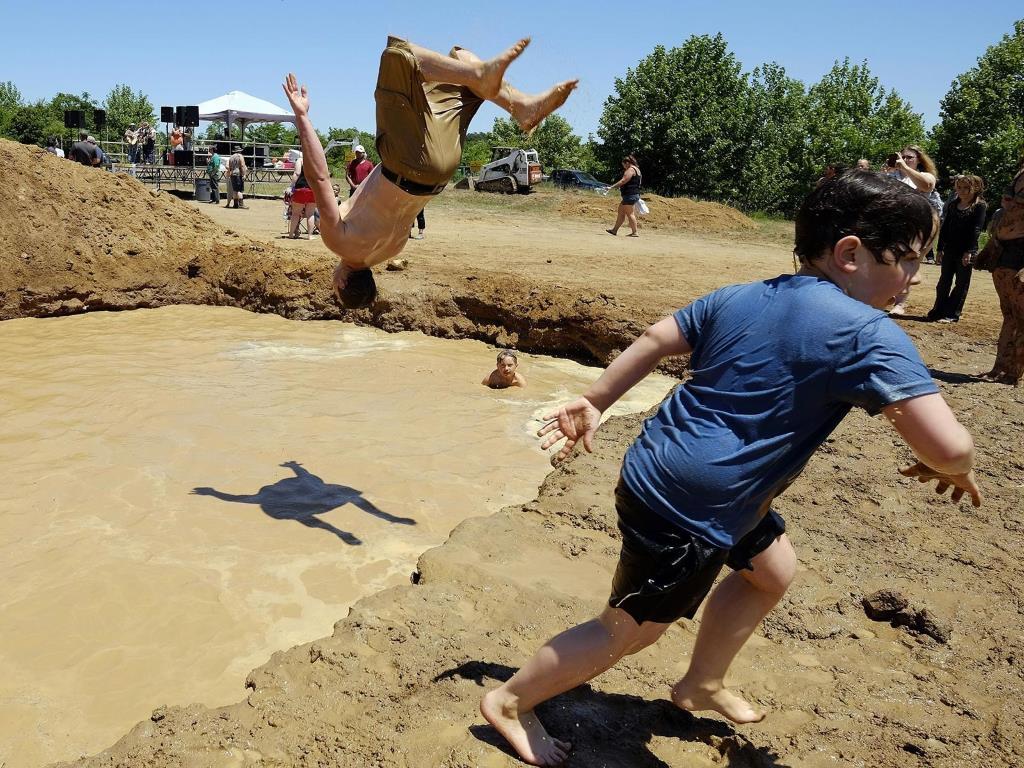 Остин Лав делает сальто в одну из грязевых ям во время National Redneck Games, которые состоялась в августе месяце в штате Джорджия.